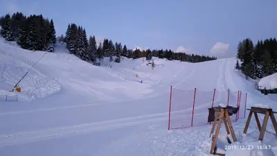a snow covered ski slope with a red fence at IL COVO DELLO SCIATORE in Falcade