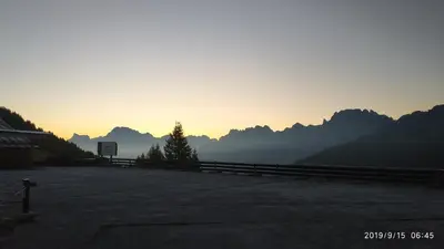 a sunset with mountains in the background and a fire hydrant at IL COVO DELLO SCIATORE in Falcade