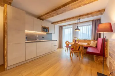 a kitchen and dining room with a table and chairs at Agriturismo MARER Urlaub auf dem Bauernhof in Villabassa