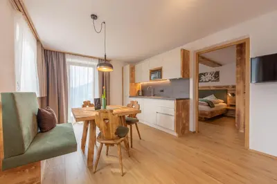 a kitchen and dining room with a table and chairs at Agriturismo MARER Urlaub auf dem Bauernhof in Villabassa