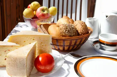 a table topped with a basket of bread and fruit at Garni & Residence Sonngart in Lagundo