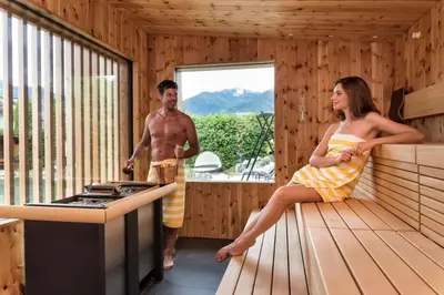 a man and a woman sitting in a sauna at Hotel Sun in Naz-Sciaves