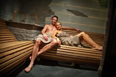 a man and a woman sitting on a bench at Hotel Sun in Naz-Sciaves