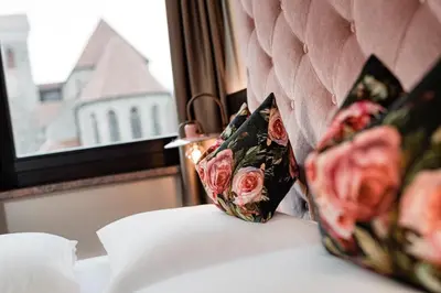 a couch with two pillows on it next to a window at Hotel Schlosswirt in Schenna