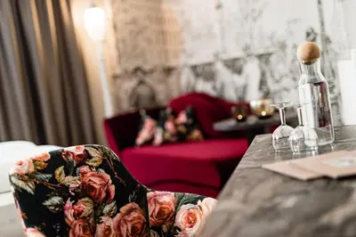 a table with a chair with a bottle on it at Hotel Schlosswirt in Schenna