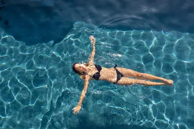 a woman laying in a pool of water at Hotel Schlosswirt in Schenna