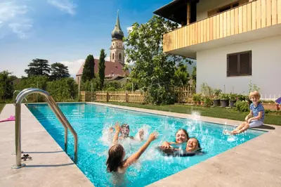 a group of children playing in a swimming pool at Obstbauernhof Bundschuh - Dogs welcome in Appiano sulla Strada del Vino