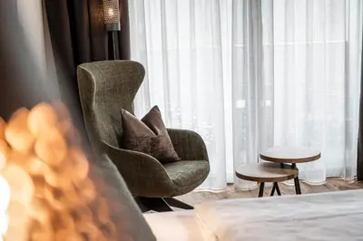 a chair with pillows in a room with a window at Hotel Klostersepp in Chiusa
