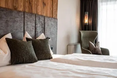 a bedroom with a bed with pillows and a headboard at Hotel Klostersepp in Chiusa