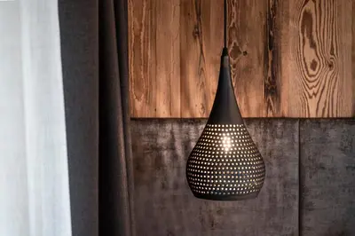 a black light hanging from a wooden wall at Hotel Klostersepp in Chiusa