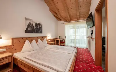 a bedroom with a bed and a television in it at Hotel Klostersepp in Chiusa