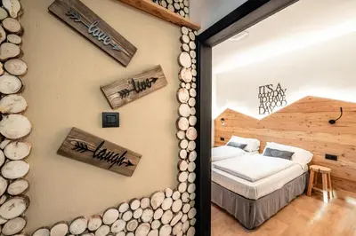 a bedroom with a bed and logs on the wall at -Antermoia- Appartament Canazei Center in Canazei