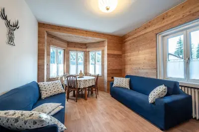 a living room with a blue couch and a table at -Antermoia- Appartament Canazei Center in Canazei