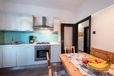 a kitchen with a table with a bowl of fruit on it at -Antermoia- Appartament Canazei Center in Canazei