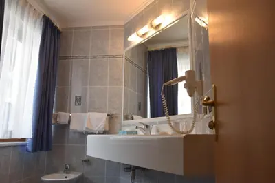 a bathroom with a sink and a mirror at Garni Haus Tyrol in Corvara in Badia