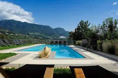 a swimming pool with mountains in the background at Pension Schweigkofler in Tirolo