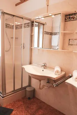 a bathroom with a sink and a shower at Pension Schweigkofler in Tirolo