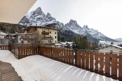 a balcony with a view of a snow covered mountain at Residence Adler in San Martino di Castrozza