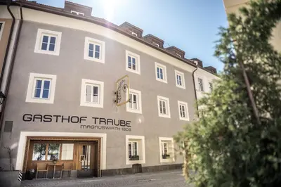 a large building with a clock on the side of it at Gasthof Traube in San Lorenzo di Sebato