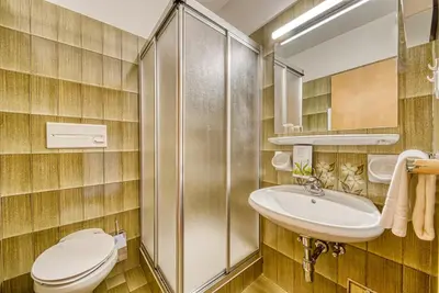 a bathroom with a toilet and a sink at Hotel Klarnerhof in Schenna