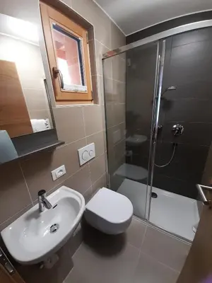 a bathroom with a toilet and a sink and a shower at Apartments Annemarie in Ortisei