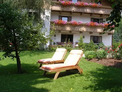 two chairs sitting in the grass in front of a building at Burgblick in San Lorenzo di Sebato