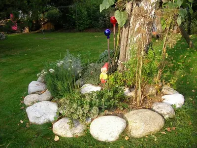 a garden with rocks and a gnome in the middle at Burgblick in San Lorenzo di Sebato