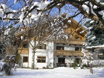 a building in the snow with snow covered trees at Burgblick in San Lorenzo di Sebato