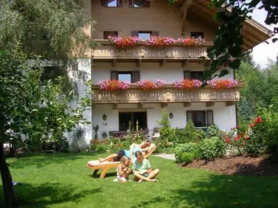 a group of people sitting on a bench in front of a house at Burgblick in San Lorenzo di Sebato