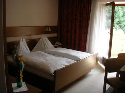 a bedroom with a bed with white sheets and a window at Burgblick in San Lorenzo di Sebato