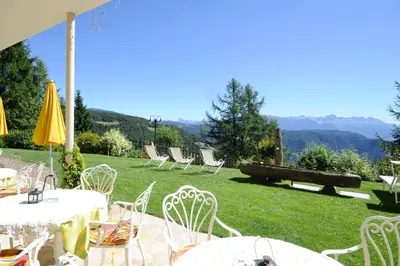 a group of tables and chairs on a grass field at Hotel König Laurin in San Genesio Atesino