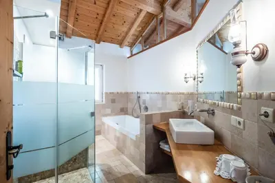 a bathroom with a glass shower and a sink at Hotel König Laurin in San Genesio Atesino