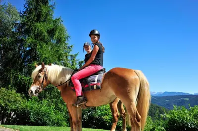 a man and a woman sitting on a horse at Hotel König Laurin in San Genesio Atesino