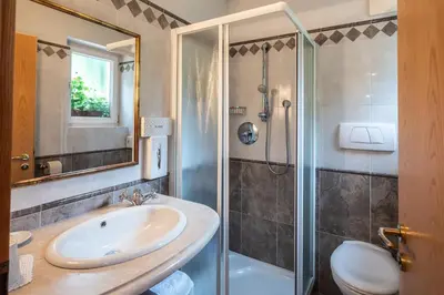a bathroom with a sink and a shower at Hotel König Laurin in San Genesio Atesino