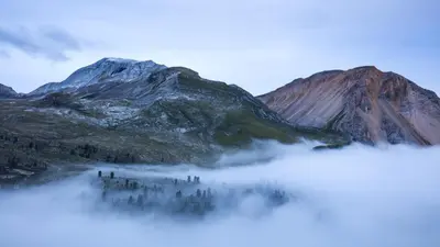 a group of people standing in the fog in front of a mountain at Lüch de Martin in La Valle