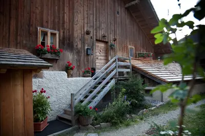 a wooden building with flowers on the side of it at Lüch de Martin in La Valle