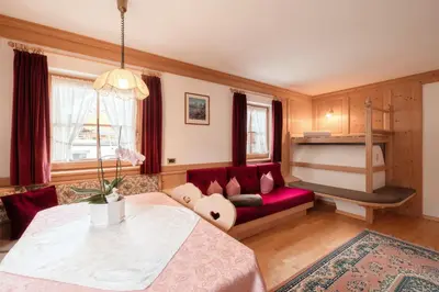 a room with two beds and a couch at Luech da Plazola in Selva di Val Gardena