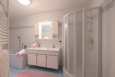 two beds in a small room with a window at Luech da Plazola in Selva di Val Gardena