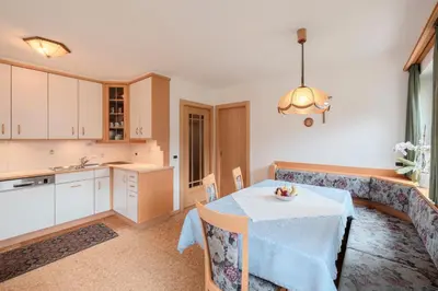 a kitchen with a table and a dining room at Luech da Plazola in Selva di Val Gardena