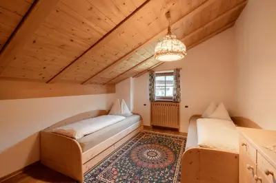 a white building with a wooden door on a mountain at Luech da Plazola in Selva di Val Gardena