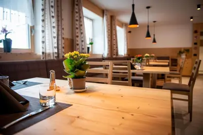 a table with a bottle of beer and flowers on it at Hotel Gran Pre in San Vigilio Di Marebbe