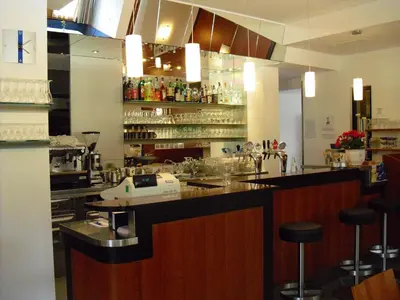 a restaurant with a bar with stools in a room at Pizzeria Restaurant Wieser in Rasùn di Sotto