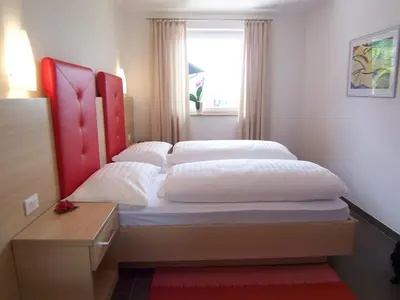 a bedroom with a bed with a red headboard and a window at Der Blaue Reiter in Schenna