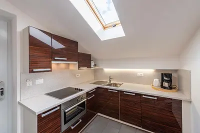 a kitchen with wooden cabinets and a skylight at Der Blaue Reiter in Schenna