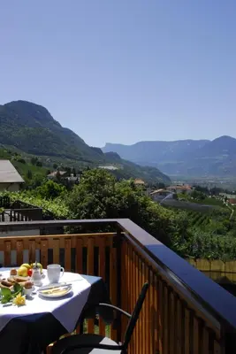 a table on a balcony with a view of mountains at Der Blaue Reiter in Schenna
