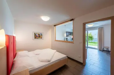 a bedroom with a bed in a room with a window at Der Blaue Reiter in Schenna