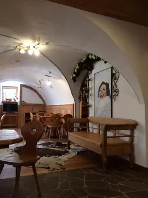a living room with a bench and a table at Hotel Garnì Salvanel in Cavalese