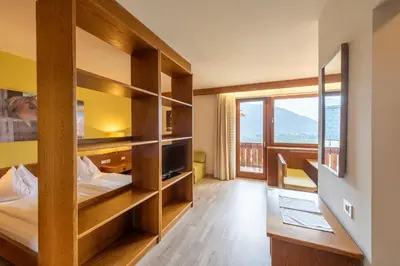 a room with two beds and a large window at Andreas Hofer in Schenna