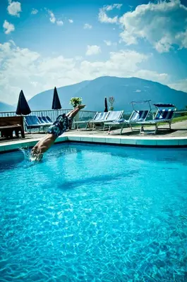 a man diving into a swimming pool at Appartement Tschivon in Schenna