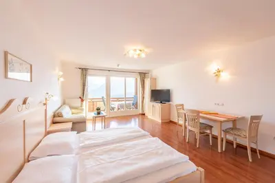 a bedroom with a bed and a table and a room at Appartement Tschivon in Schenna